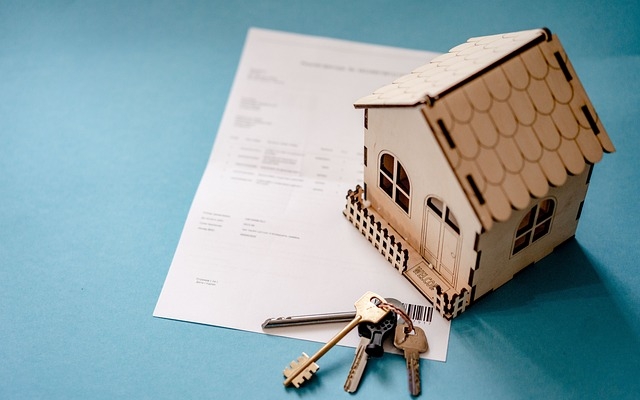 image with a house model and keys over a sheet of paper
